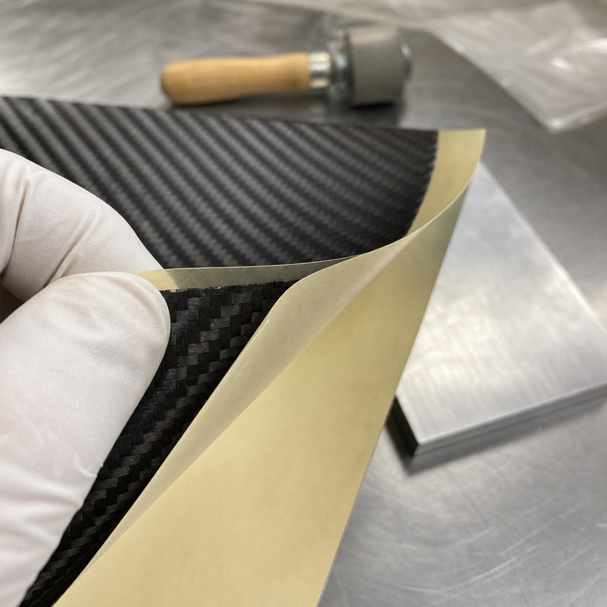 Adhesive backed flexible carbon fiber sheet with peel-off liner